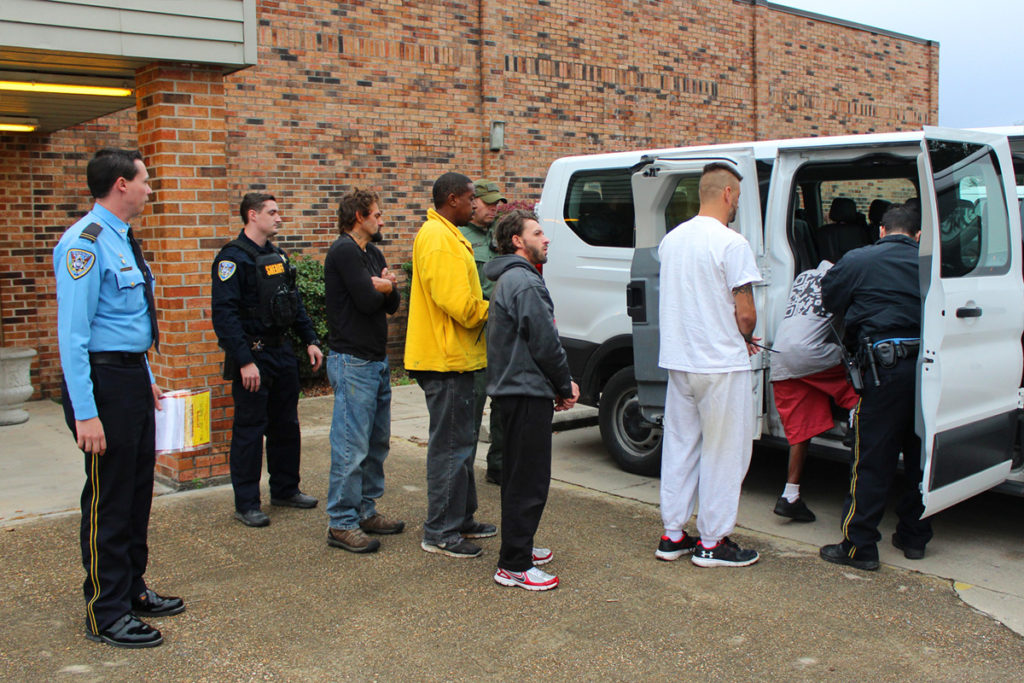 Deputies escort individuals arrested as part of Thursday's roundup. 