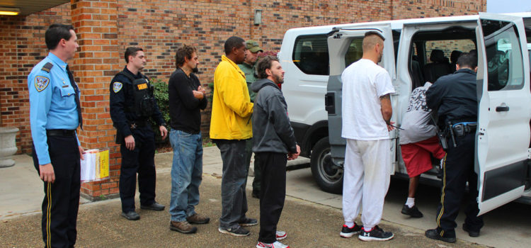Deputies escort individuals arrested as part of Thursday's roundup.