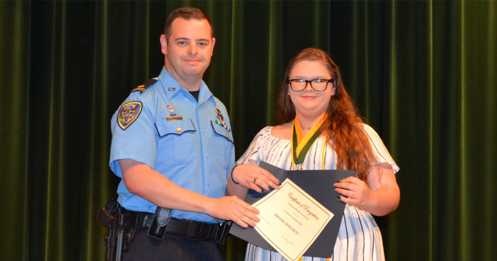 Lt. Brennan Matherne presents a certificate for the LSA Scholarship to Brooke Bergeron.