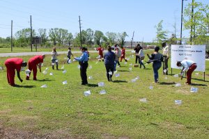 Participants in the White Flag Exposition plant flags on the front lawn of the Lafourche Parish Correctional Complex.